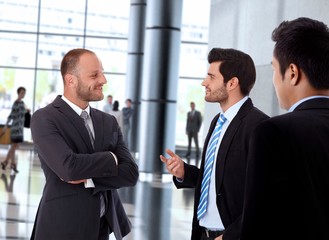 Smiling businessmen talking inside office building