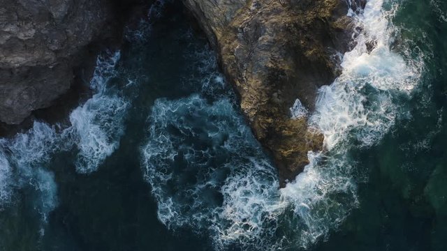 Flying Above Waves Crashing of Rocks. Aerial view of Turquoise Waves in the sea 