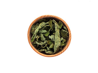 Dry BlackBerry leaves in a wooden Cup on a white background