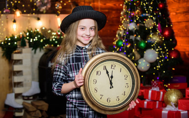 Hurry up to make wish. Girl santa claus hat and clock. Meet Christmas holiday. Festive atmosphere...