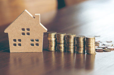 Modeling wooden houses and coins and dollars placed on wooden tables,preparation concept for house model purchase and the fastest growing real estate economy,moving home or renting property via agent