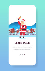 santa claus holding bell merry christmas happy new year holiday concept smartphone screen online mobile app winter houses snowy town street greeting card full length vertical vector illustration
