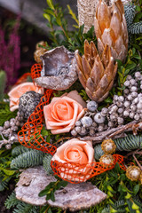 Lieblicher Grabschmuck mit lachsfarbenen Rosen und verschiedenen Zapfen