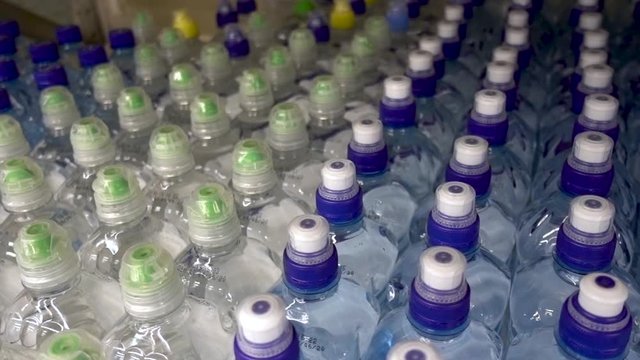 Plastic water bottles, caps. Camera in motion, top view