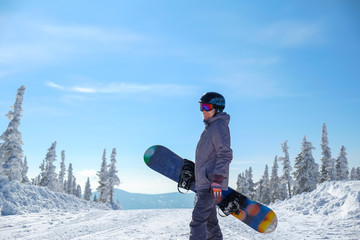 Young snowboarder riding in the mountains on a snowboard.