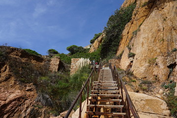 Fototapeta na wymiar Sant Feliu de Guixols - walking path along the coastline and stairs to the top of rock