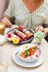 Woman eating pink pancake.