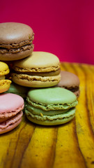 Colored macarons isolated on wooden dish, typical French dish