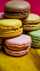 Colored macarons isolated on wooden dish, typical French dish