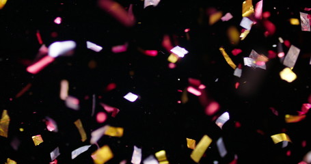 Confetti fired in the air during a party. Only confetti on black background of the night. Falling...