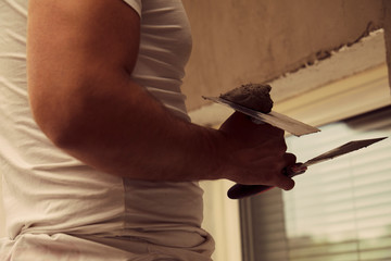 Construction worker plaster a wall.