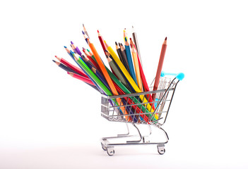 Classic shopping cart with colour pencils isolated on white background