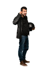 Full-length shot of Biker man listening to something by putting hand on the ear over isolated white background