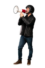 Full-length shot of Biker man shouting through a megaphone over isolated white background