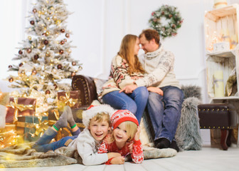  happy family with gifts near Christmas tree at home