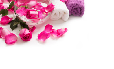 Fototapeta na wymiar Pink roses petals in bowl with towels and pure water over white.. Spa and wellness concept