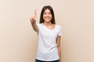 Pretty young girl over isolated background showing and lifting a finger