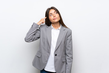 Young business woman over isolated white background making the gesture of madness putting finger on the head
