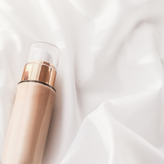 Tonal bb cream bottle make-up fluid foundation base for nude skin color on silk background,...
