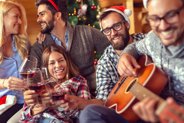 Friends singing Christmas songs and drinking wine