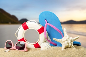 Beach accessories on sand. Flip flops, sunglasses, sea star