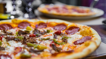 Pizza with Mozzarella cheese, salami, Tomatoes, hot pepper, Spices. Italian pizza on wooden table background