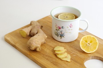 Closeup shot of ginger and ginger tea with lemon in the decorative container