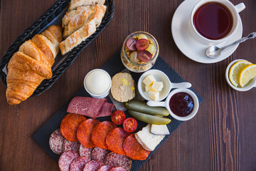 Brunch or breakfast set, meal variety with boil egg, salami, meat and cheese variety, granola, smoothie, fruits and berries. Served with bread and a cup of tea