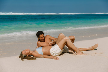 Fototapeta na wymiar Young pregnant woman with husband at paradise beach. Happy couple at tropical island