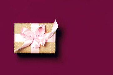 Luxurious gift on a burgundy colors. Copy space. Present for St. Valentine's day, weddings, engagements, Mother's Day, birthday, New Year, Christmas, holidays