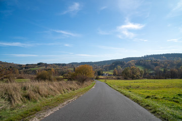 Panoramic view of fields near Gluszyca and Walbrzych. Autum sunny weather, vivid colors. Tarmac road in the middle