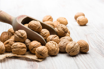 bunch of walnuts with wooden scoop on table