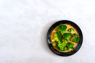 Boiled broccoli on a plate on a light background. Healthy eating concept. Sports diet. Proper nutrition. Healthy lifestyle. Free space. Top view.