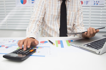 Businessmen are calculating and analyzing performance statistics for future investments.