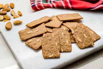 Crispy Almond Thins Cookies / Wafer with Nuts on Marble Board.