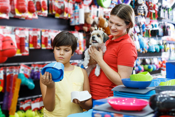 boy and his mother looking for supplies for little dog