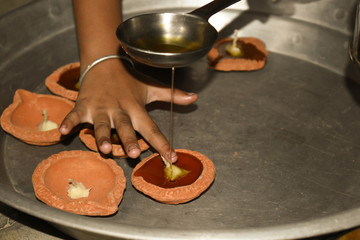 A child decorating clay lamp in diwali celebration