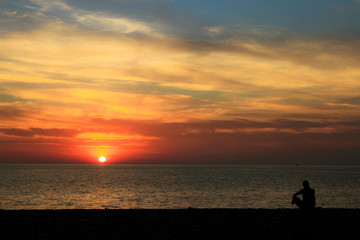 silhouette of man on beach at sunset