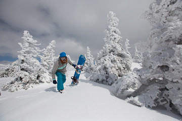Happy snowboarder in winter snowy forest