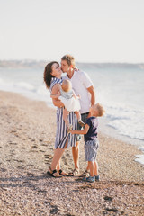 Happy family having fun near sea at the beach.