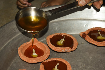 Filling oil in diyas during deepawali festival in India