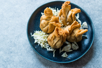 Nepalese Traditional Deep Fried Dumpling Momos served with Tomato Chutney, Schezwan sauce and Cabbage salad.