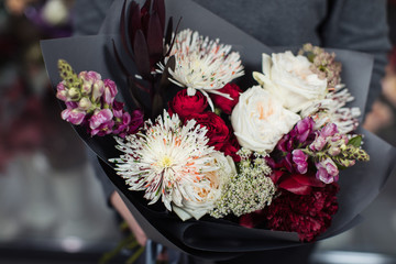 Beautiful bouquet of mixed flowers with peonies. The work of the florist. Flower delivery