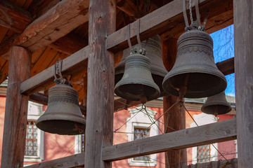 Several bronze church bells hung on a wooden beam