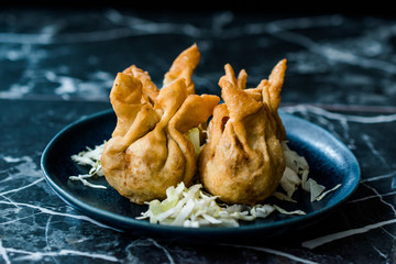 Nepalese Traditional Deep Fried Dumpling Momos served with Tomato Chutney, Schezwan sauce and Cabbage salad.