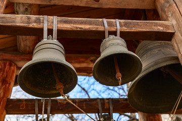 Fototapeta premium Three bronze church bells hung on a wooden beam