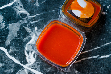 Hot Spicy Red Sriracha Sauce in Plastic Box / Package or Container for Fast Food Ready to Eat.