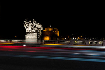 Fototapeta na wymiar light trails on the Vittorio Emanuele II bridge, in the background Castel 'Angelo