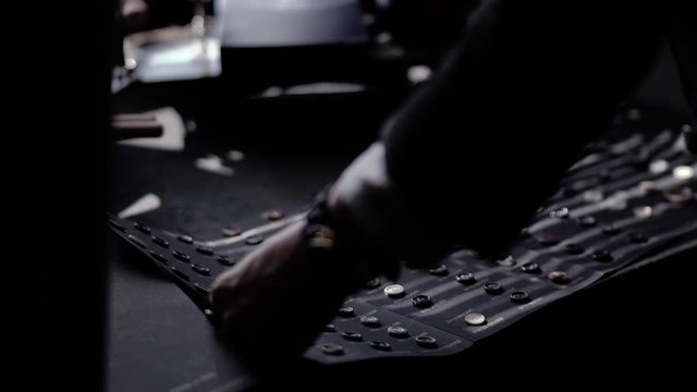 girl in jacket and a white shirt with hours and rings on drawn opens box with buttons