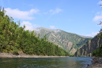 Mountain river landscape in Siberia - stream of a mountain river running between mountains in summer. River Oka Sayan, East Saiyan, Russia.